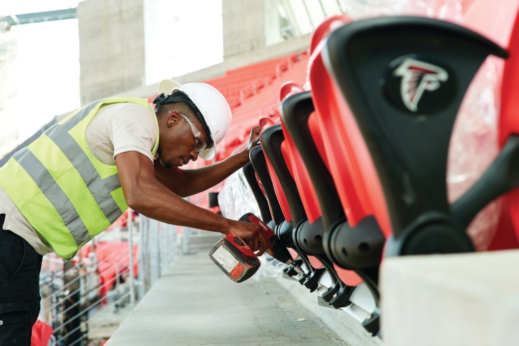 Construction Worker Installing Stadium Seats